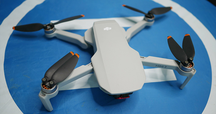 DJI Mini drone on a landing pad in snow and cold weather